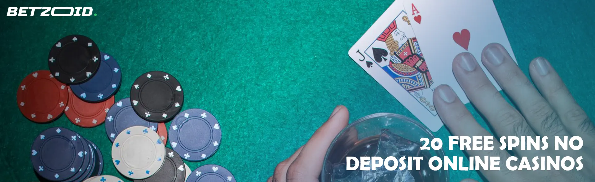 A player holds cards next to casino chips and a drink in a glass.