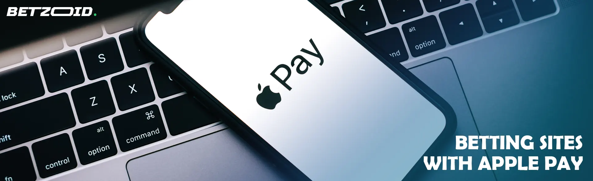 A smartphone with the Apple Pay logo on the screen rests on the keyboard.