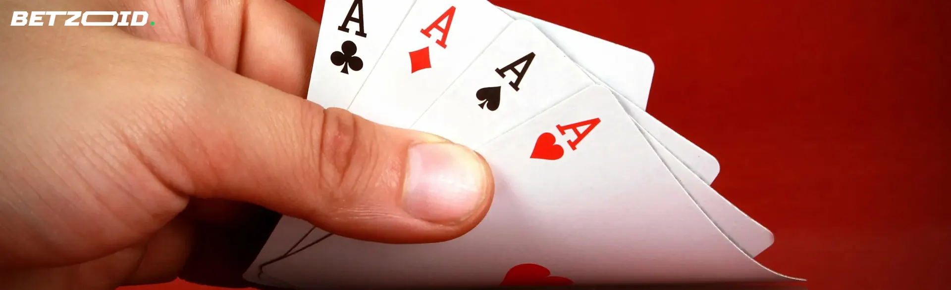 Jogando cartas na mão sobre um fundo vermelho.
