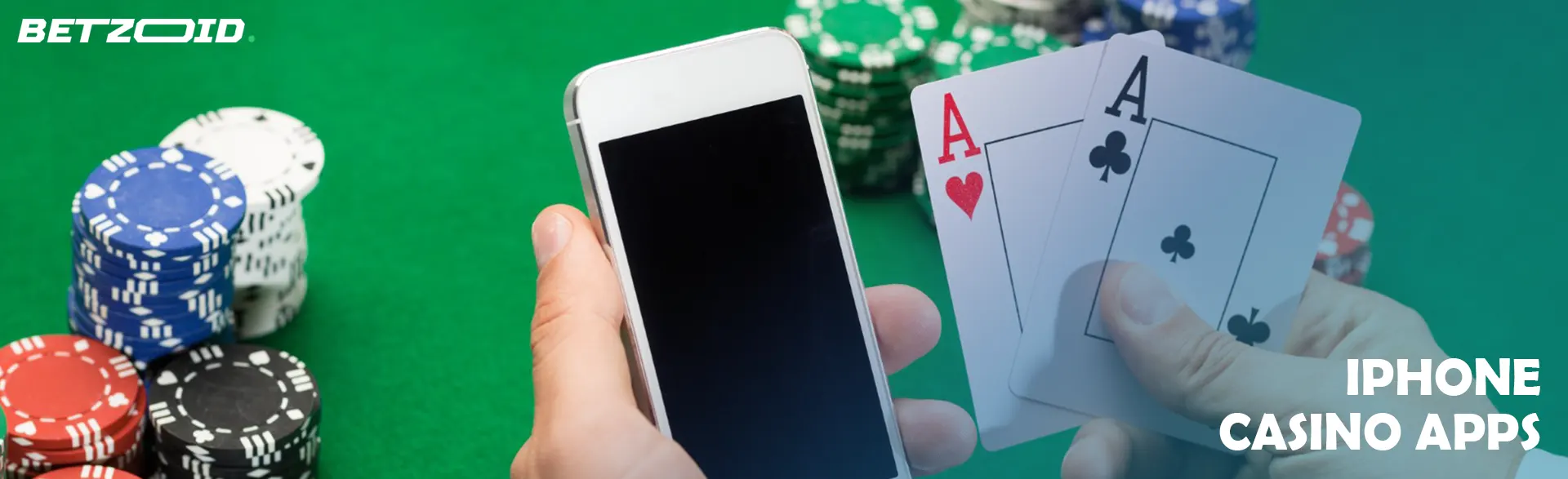 A player holds a smartphone and cards next to casino chips.