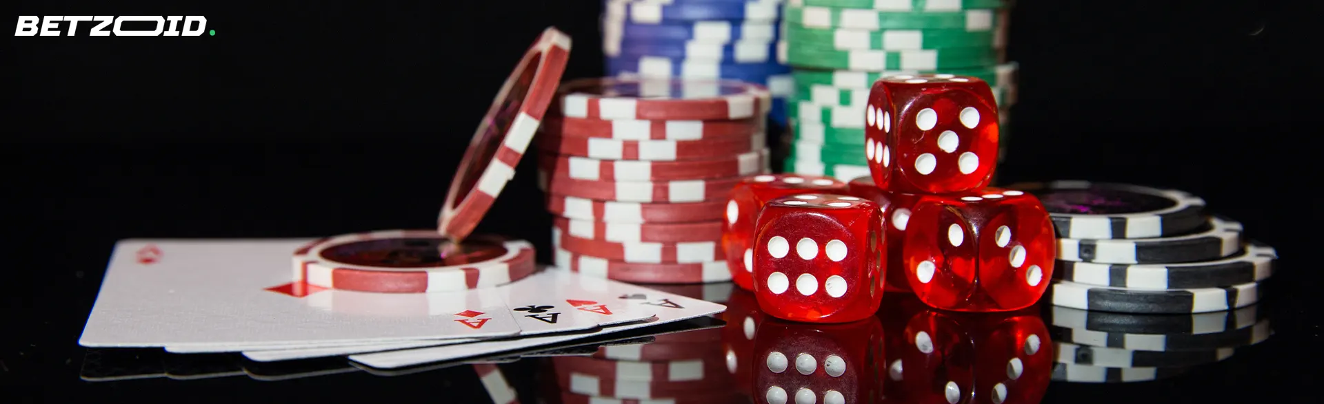 Würfel, Casino-Chips und Karten auf dunklem Hintergrund.