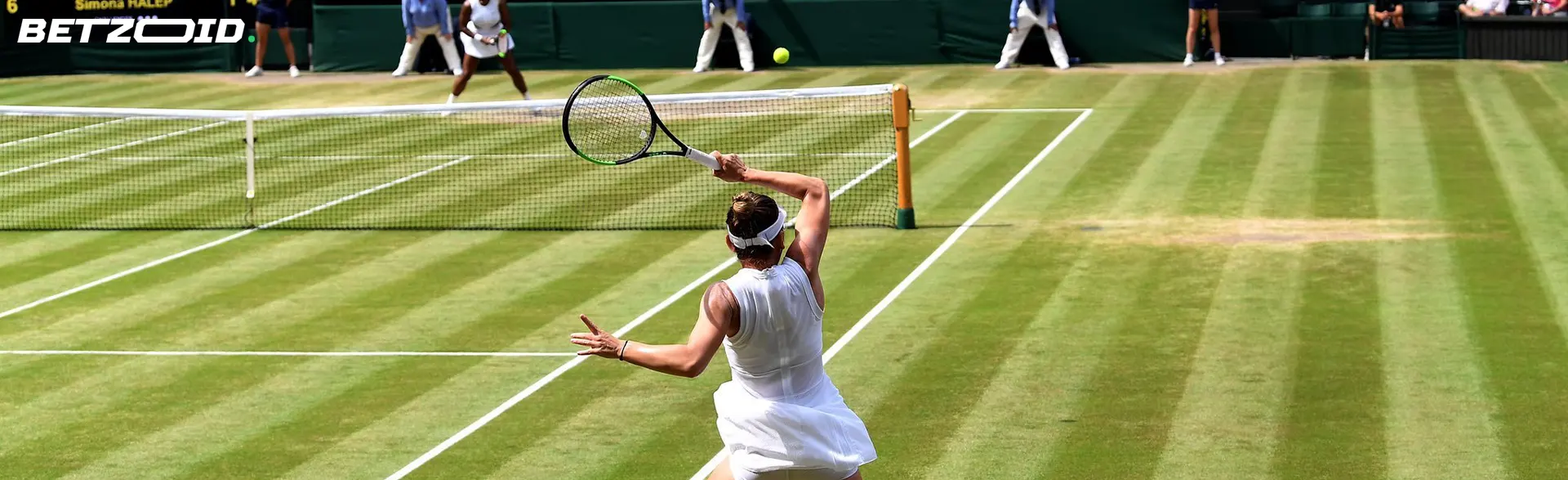 Giocatrice di tennis in campo in erba durante un colpo.