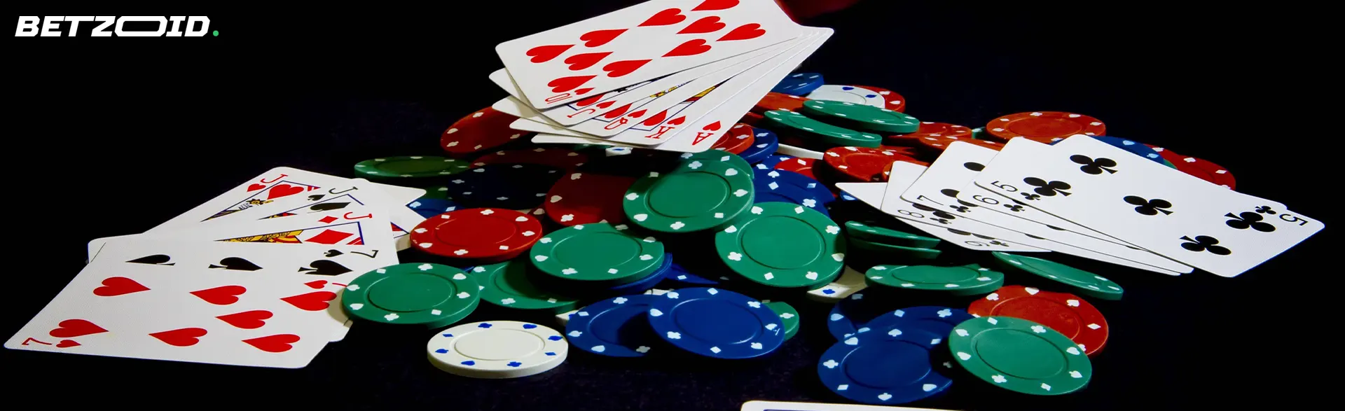 A pile of chips and cards on a dark background.