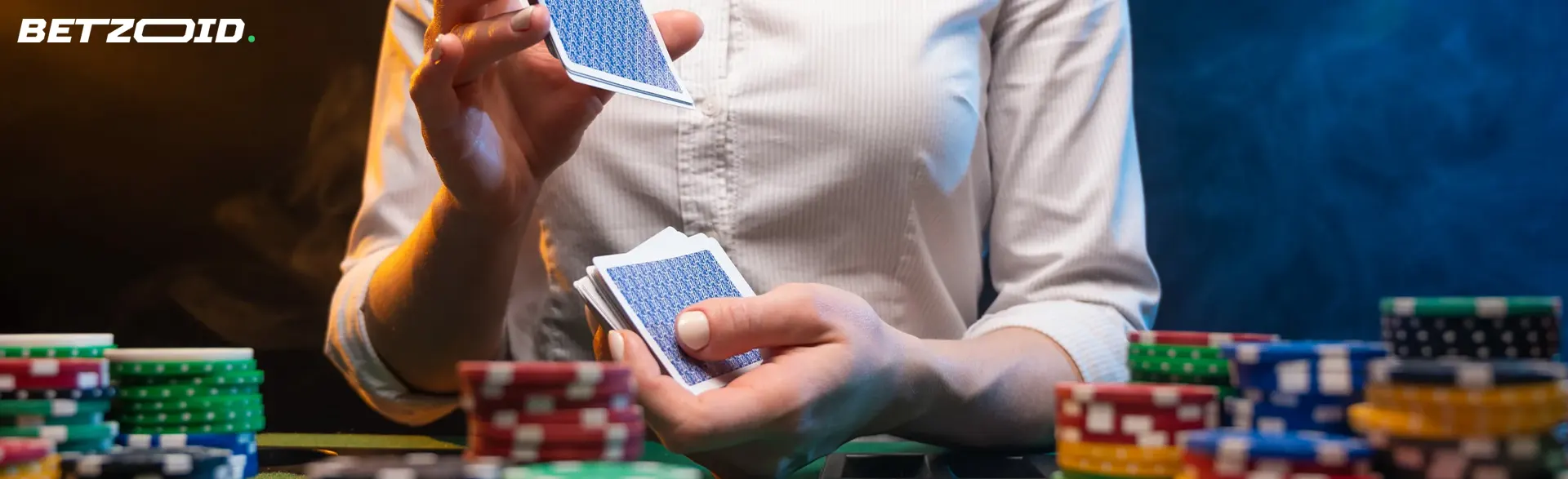 O jogador embaralha as cartas ao lado das fichas do casino.