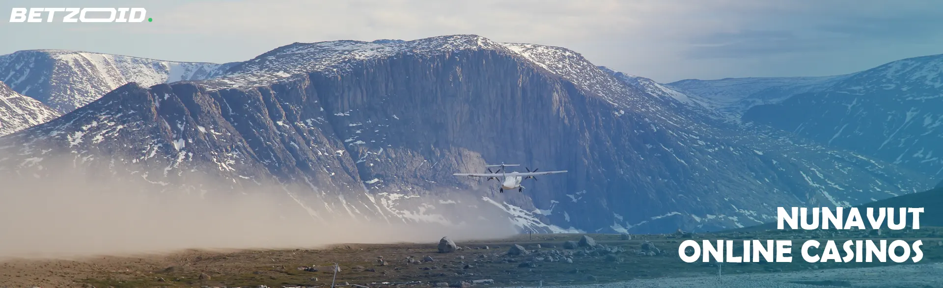 A plane taking off with rugged, snowy mountains in the background, capturing the remote beauty of Nunavut online casinos.