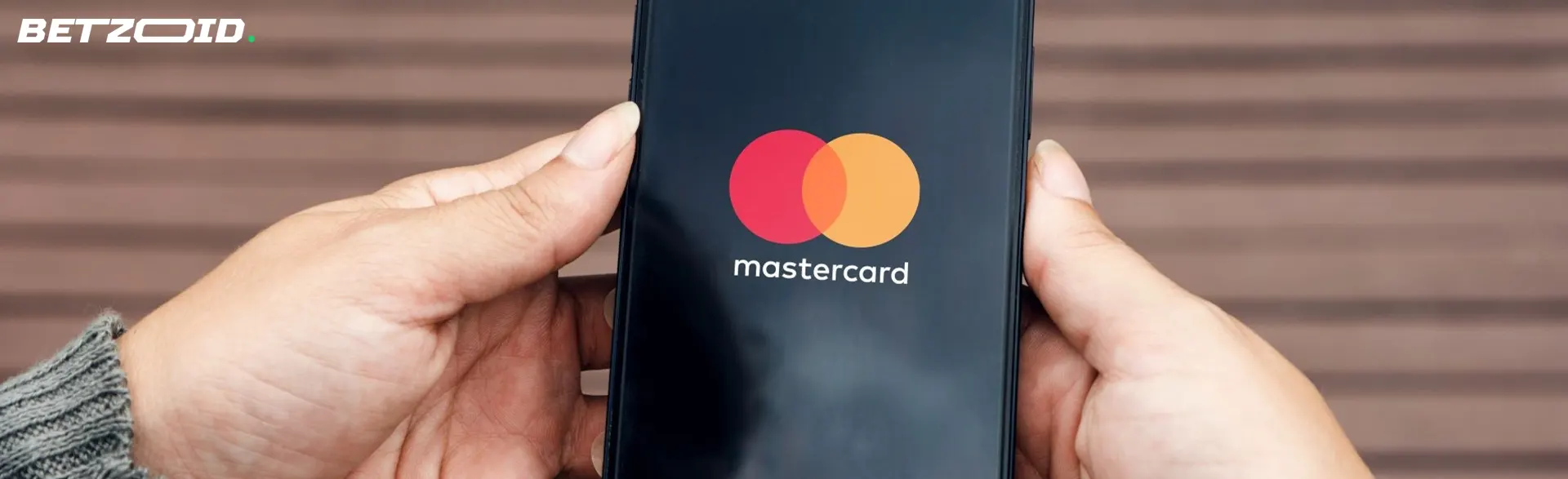 Logotipo Mastercard na tela do smartphone nas mãos.
