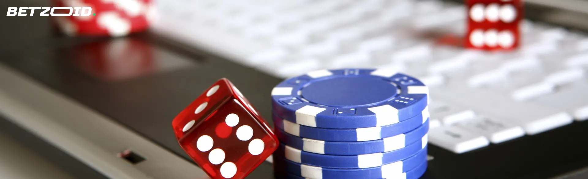 Casino chips and dice on laptop keyboard.